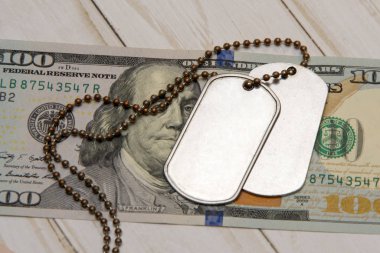 Yüz dolarlık banknotta ordu kimlik madalyonları var. Konsept: Ordu emekliliği, orduda maaş, ordu sigortası, paralı askerler ve müteahhitler.