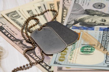 Amerikan dolarlarının üzerinde ordu madalyonları var. Konsept: askeri operasyonlar için ödeme, askeri personelin finansmanı, sözleşmeli askerlik, paralı askerler.