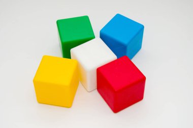 Beyaz arka planda çocukların renkli küpleri, çocuk oyuncakları, eğitim oyunları.