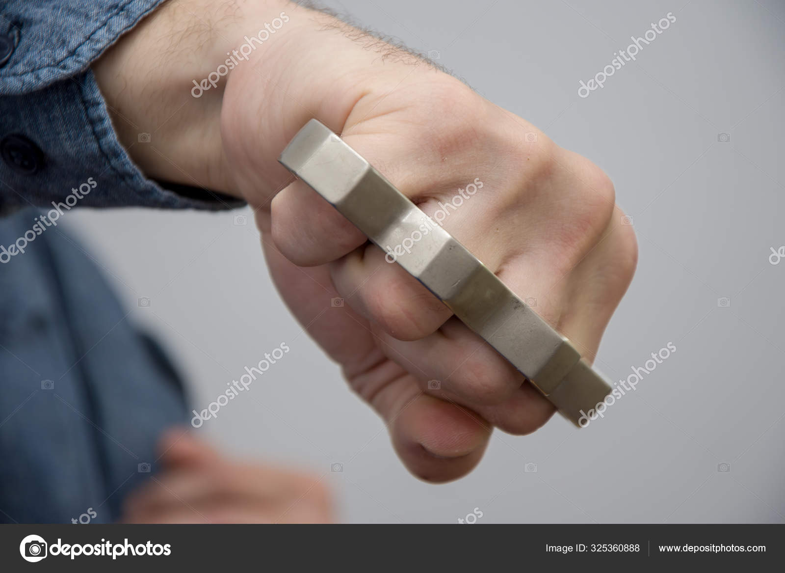 Blow with Brass Knuckles. the Hand of an Elderly Woman Clutches a