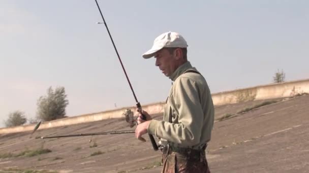 Male Fisherman Collects Spinning Rods Shore Puts Them Boat Preparing — ストック動画