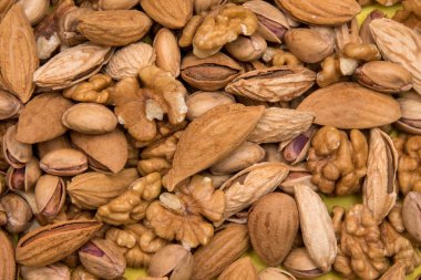 Sarı desenli kağıtta çeşitli kurutulmuş fındıklar bulunur. Soyulmuş ceviz, fıstık ve badem..