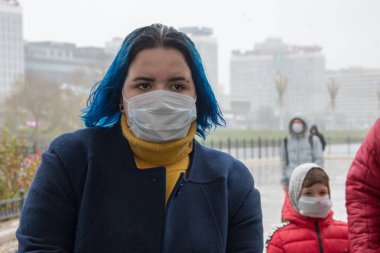 Şehirde bulaşıcı hastalık tehlikesi var. Sokakta virüs bulaşma riski var. Yoldan geçenler - tıbbi maskeli adamlar caddede yürüyorlar. Önlemler, hastalıkların önlenmesi.