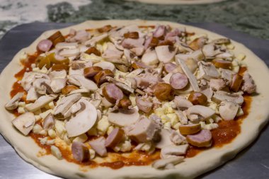 Mantarlı ve domatesli pizza pişirmek, jambon ve sos, çiğ pizza.