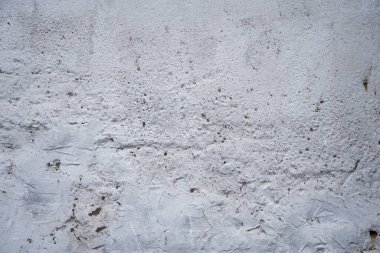 Beton bir duvarın dokusu, dengesizce sıvanmış, rutubet, pürüzler ve düzensizlikler yüzünden lekeler..
