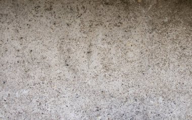 Beton bir duvarın dokusu, dengesizce sıvanmış, rutubet, pürüzler ve düzensizlikler yüzünden lekeler..