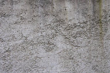 Beton bir duvarın dokusu, dengesizce sıvanmış, rutubet, pürüzler ve düzensizlikler yüzünden lekeler..