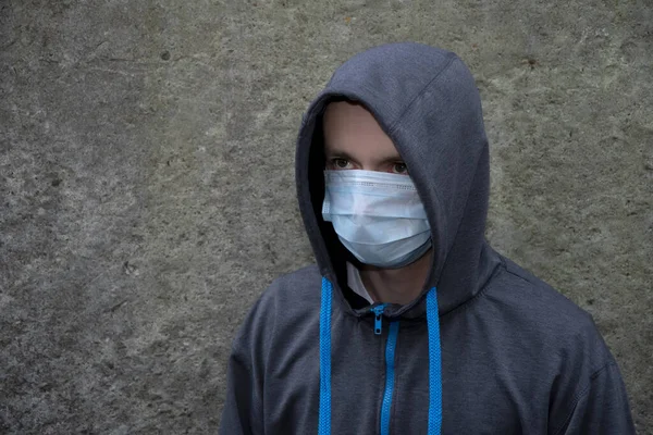 Young Guy Hooded Sweatshirt Medical Mask Concrete Wall Personal Safety — Stock Photo, Image