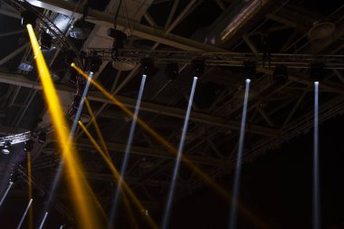 Sahne ışıkları. Performansın sahnesi projektörlerle aydınlatılıyor. Dumanın içinden bir ışık huzmesi geçiyor. Konserler ve spor sahaları için ışıklandırma ekipmanları..