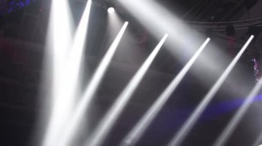 Sahne ışıkları. Performansın sahnesi projektörlerle aydınlatılıyor. Dumanın içinden bir ışık huzmesi geçiyor. Konserler ve spor sahaları için ışıklandırma ekipmanları..