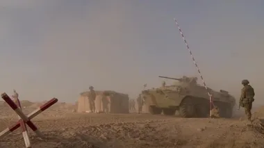 Askeri ağır zırhlı araçlar, çöl kumlarında bir çarpışma operasyonu için Rus kontrol noktasından ayrılıyorlar. Doğu ülkelerindeki askeri operasyonlar.