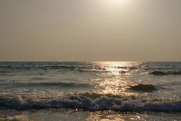 海の上の雲のない夕日 暗い海の波 太陽のまぶしさと色の照明 — ストック写真