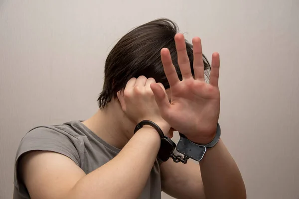 Handcuffed Teenager Covers His Face His Hands Gray Background Medium — Stock Photo, Image