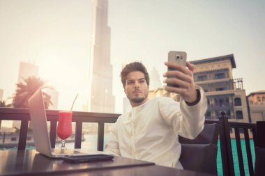 Selfie fotoğrafta Kandura giyen Smartphone'da Arap genç adam