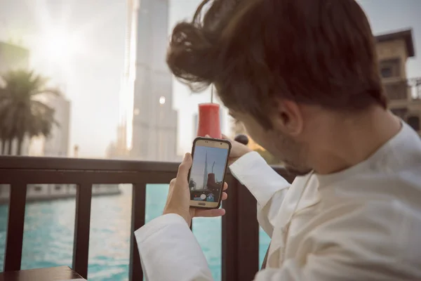 Arap genç adam alarak resmi Kandura Dubai giyen smartphone için