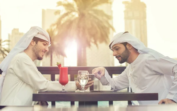 Dois árabes a falar. eles se sentam a uma mesa em um café, e beber — Fotografia de Stock