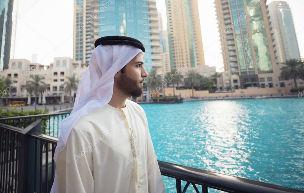 Arab young man looking to Dubai skyline 