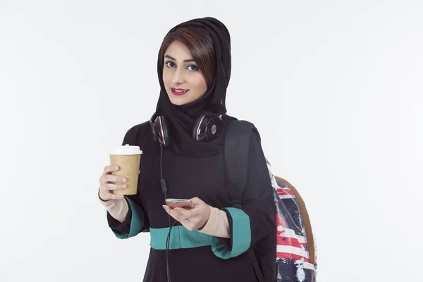 Arap öğrenci telefon tutarak hijab ve kahve fincanı 