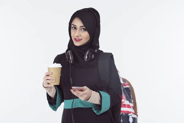 Arap öğrenci telefon tutarak hijab ve kahve fincanı 