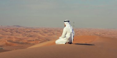 Arap Emirlikleri adam bir kumul BAE Çöl üstüne oturuyor 
