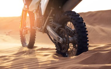 Gün batımında çölde motokrosa yakın.
