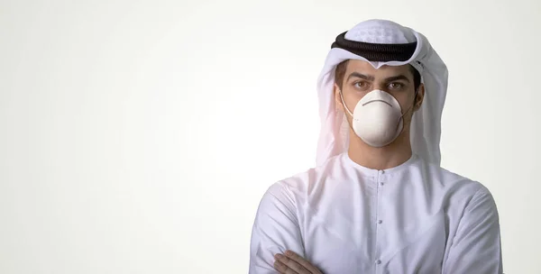 Tıbbi maske takan Arap adam kendini koronavirüsten koruyor.
