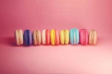 Macroons pembe bir arka plan üzerinde parlak gıda fotoğraf