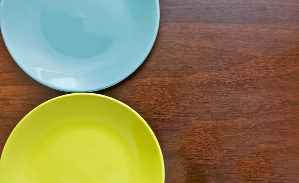 Пустая синяя и зеленая плита на деревянном фоне — стоковое фото