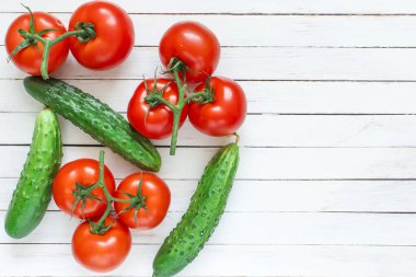 Taze salatalık ve domates Beyaz ahşap zemin üzerinde. Metin için yer.