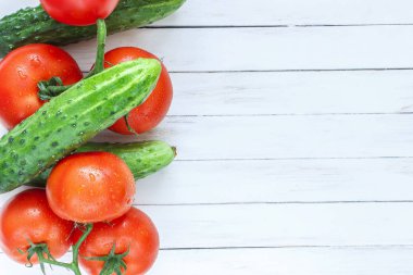Taze salatalık ve domates Beyaz ahşap zemin üzerinde. Metin için yer.