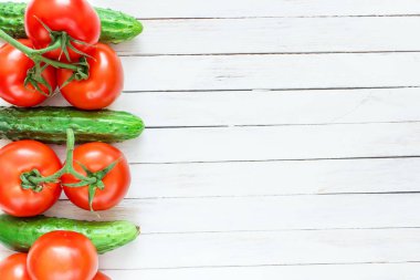 Taze salatalık ve domates Beyaz ahşap zemin üzerinde. Metin için yer.