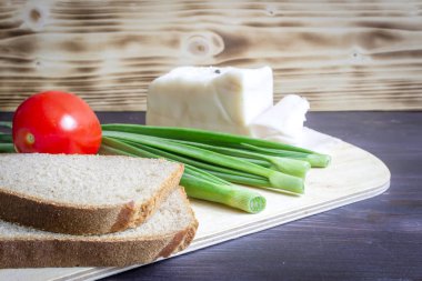 Domuz yağı, Salo, yeşil soğan, ekmek, ahşap arka plan üzerinde kırmızı domates.