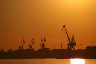 Novgorod. Volga Nehri. Kırmızı günbatımı karşı Vinçler.