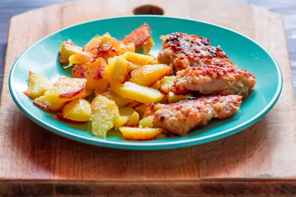 Ev yapımı tavuk nuggets mavi bir tabak kızarmış patates ile