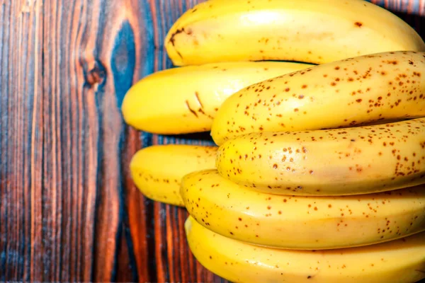 Manojo de plátanos amarillos orgánicos maduros crudos sobre fondo de madera — Foto de Stock