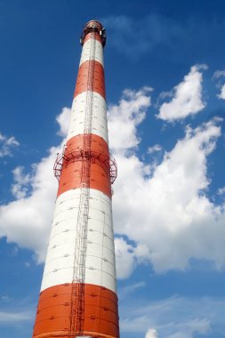 Kırmızı-beyaz baca büyük bir bitki. Alt görünümü. Mavi gökyüzü arka plan üzerinde.