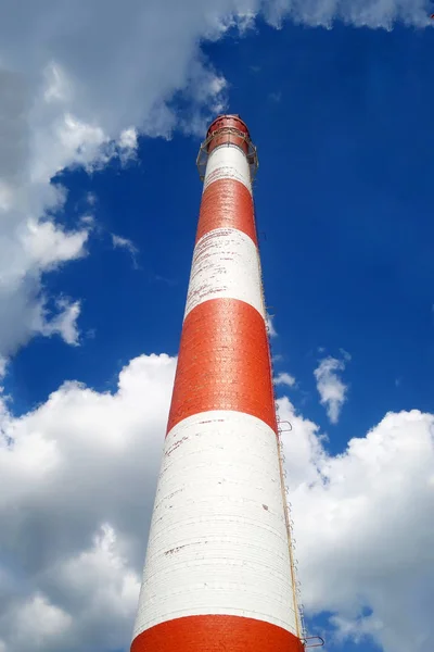 Camino rosso-bianco di una grande pianta. Vista dal basso. Sullo sfondo del cielo blu . — Foto Stock