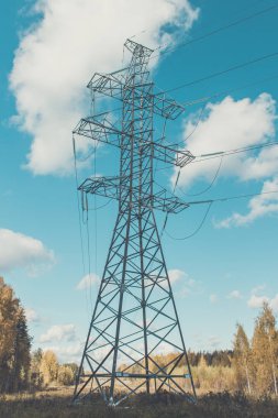 Yüksek voltajlı elektrik hatları mavi gökyüzü bulutlu destekler. Elektrik Sanayi.