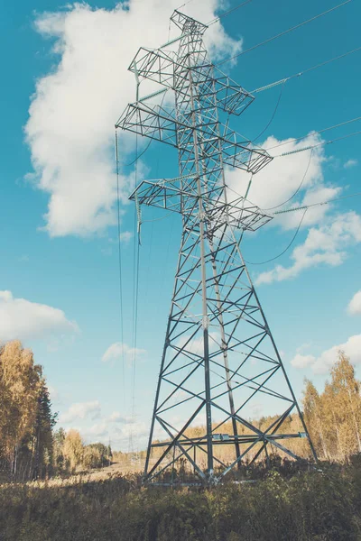 Soporta líneas eléctricas de alto voltaje contra el cielo azul con nubes. Industria eléctrica . —  Fotos de Stock