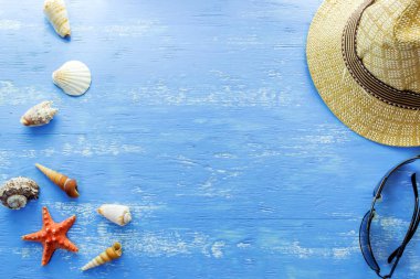 Cockleshells mavi ahşap arka plan üzerinde tatil plaj aksesuarları gözlük şapka