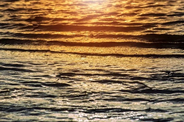 Pôr do sol refletindo sobre a superfície da água do lago . — Fotografia de Stock