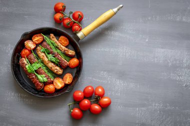 Izgara domuz sosisi ya da dökme demir tavada sosis ya da domatesli kızartma tavası, dereotlu ve yeşil soğanlı