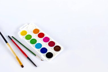 İzole edilmiş beyaz bir arkaplanda boya ve fırçalar