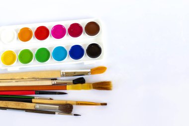 İzole edilmiş beyaz bir arkaplanda boya ve fırçalar