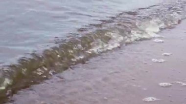 Dalgalar nehrin kumlu kıyısına vuruyor..