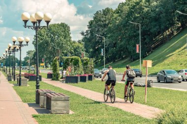 Nizhniy Novgorod, Rusya 15 Temmuz 2018. Bisikletçiler güzel yeşil bir ara sokakta gezerler.