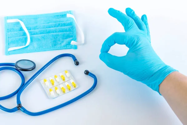 Male hand in a medical glove holds an OK sign. Isolated on white photo.