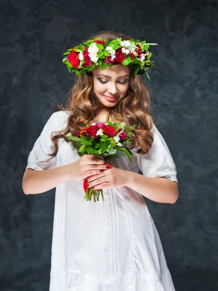 Belle fille brune avec une composition de fleurs — Photo