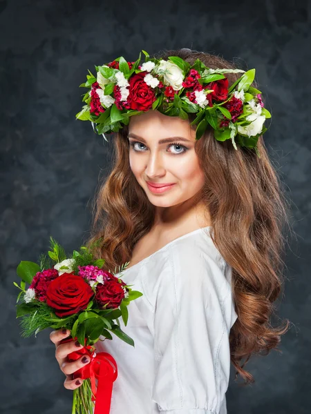 Belle fille brune avec une composition de fleurs — Photo