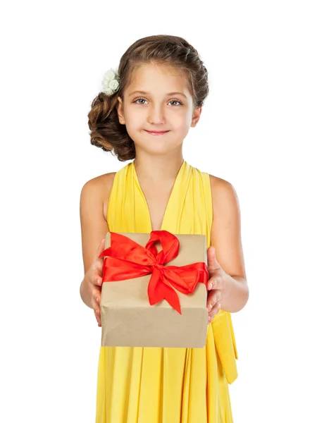 Klein meisje in een slimme jurk en kapsel bedrijf van een gift — Stockfoto